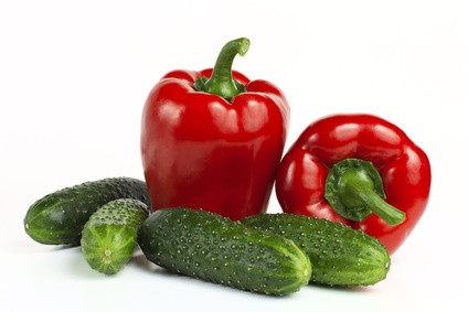 Pile of cucumbers and bell peppers over white background. | MakeSauerkraut.com
