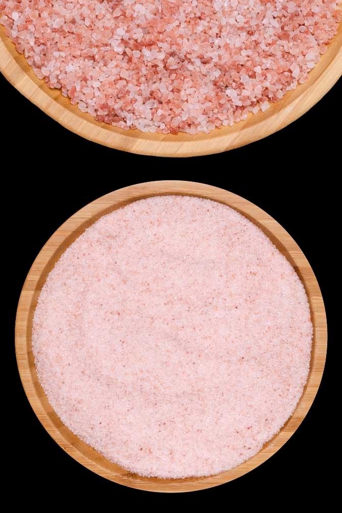 Himalayan Pink Salt for fermentation inside wooden bowl over black background. | MakeSauerkraut.com