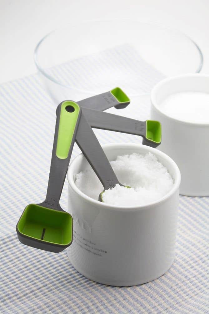 Measuring spoons in white bowl of salt. | MakeSauerkraut.com