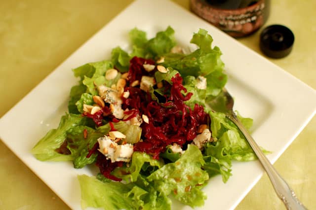 Salad with Passion Pink Sauerkraut top over white plate and a fork to the side. | MakeSauerkraut.com