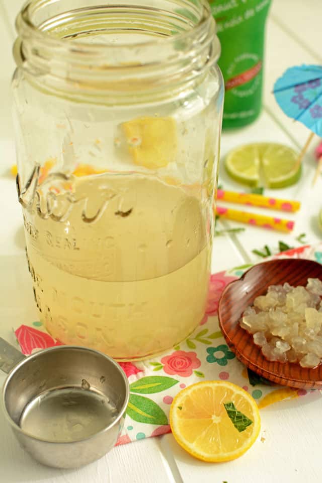 A jar with diluted water kefir grains, saucer of water kefir grains, metal scoop and lemon. | MakeSauerkraut.com