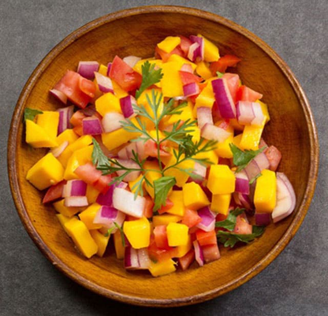 Jicama chunks in mango salsa in a round, wooden bowl. | MakeSauerkraut.com