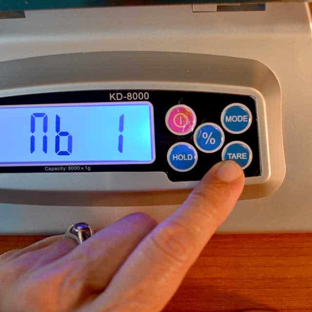 Fingers reaching to press "tare" on the MyWeigh KD-8000 digital scale. | MakeSauerkraut.com