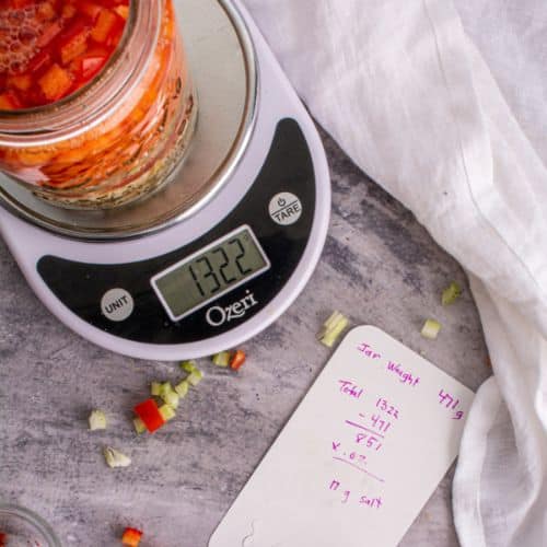 Jar packed with carrots sitting on digital scale. | MakeSauerkraut.com
