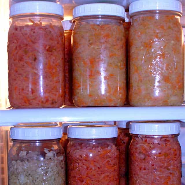 Two rows with three jars each of fermented sauerkraut with white lids. | MakeSauerkraut.com