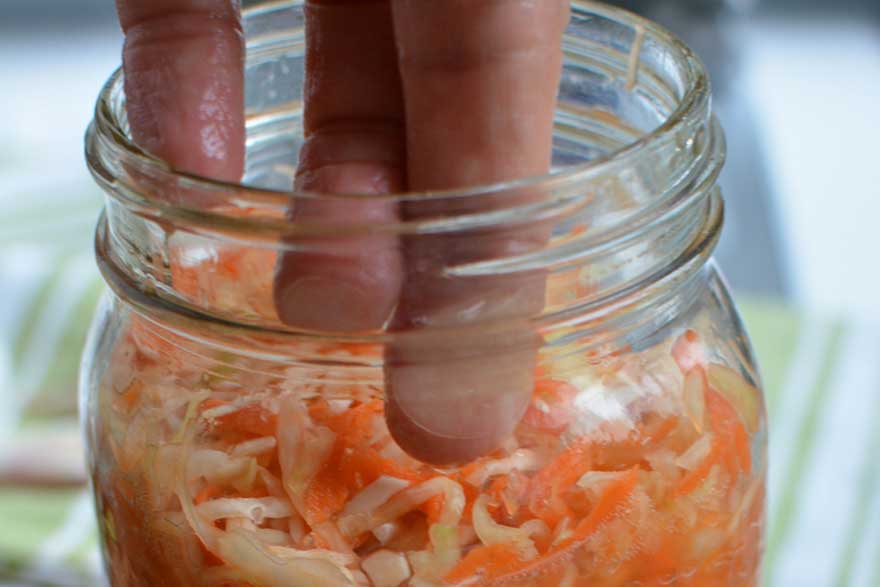Push down any tidbits on the inside of the jar. | MakeSauerkraut.com