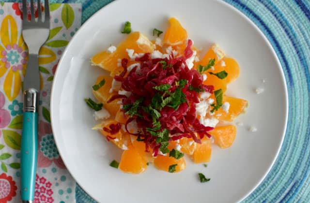 A plate filled with Passion Pink Sauerkraut over a winter salad. | MakeSauerkraut.com