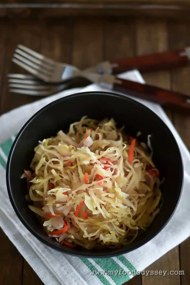 Top image of black bowl with Lithuanian sauerkraut over white cloth. | MakeSauerkraut.com