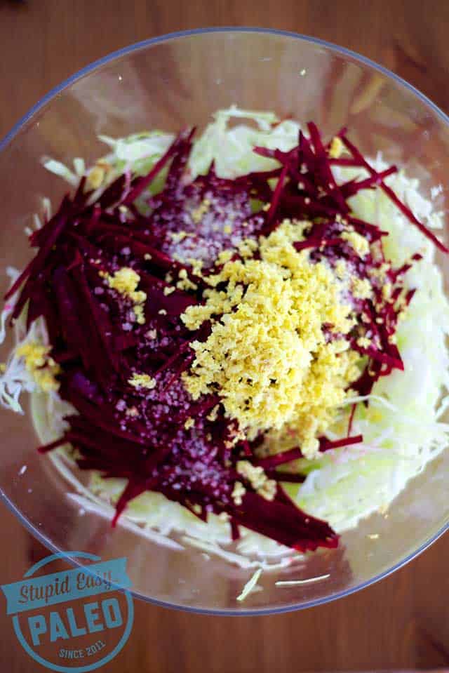 Top view of beet ginger sauerkraut in a clear mixing bowl. | MakeSauerkraut.com