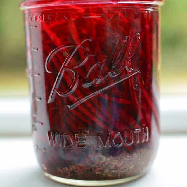 Front view of transparent glass jar with the fermented red beets. | MakeSauerkraut.com