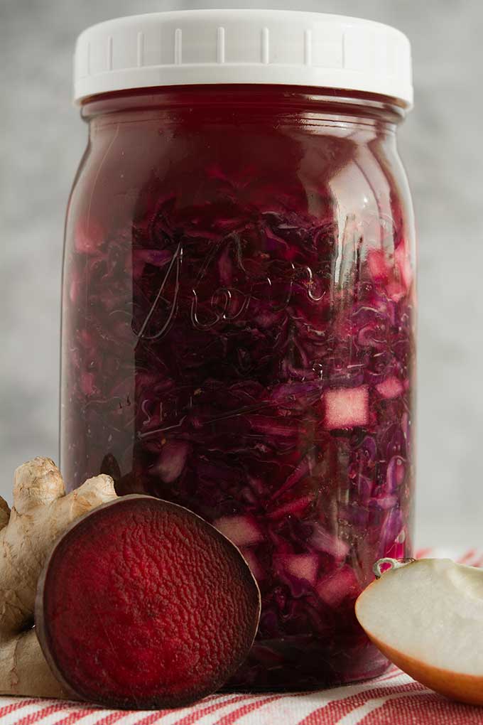 Front view of a jar filled with Ruby-Red Red-Cabbage Sauerkraut with a white lid. | MakeSauerkraut.com