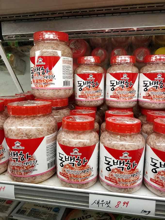 Rows of Salted shrimp containers in a Korean market rack. | MakeSauerkraut.com