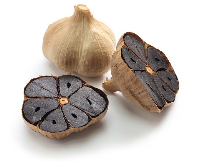 1 full bulb of black garlic and 2 halves cut vertically to show black cloves. | MakeSauerkraut.com