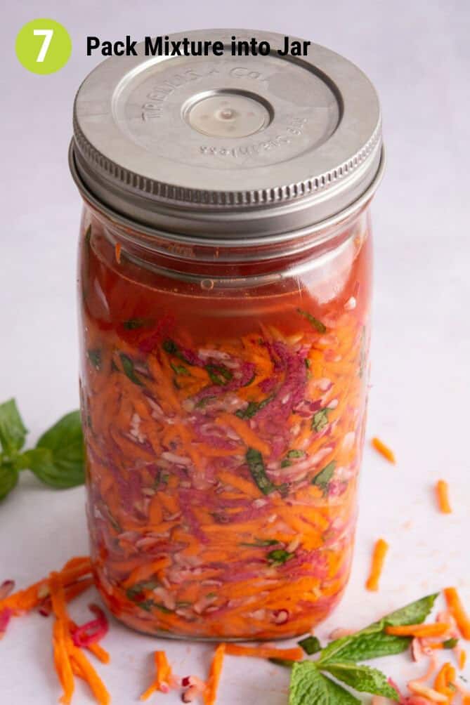 Finished packed jar of ingredients for Fermented Radish and Carrots Slaw with chopped ingredients at the side. | MakeSauerkraut.com