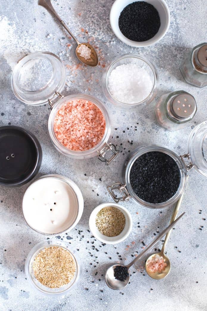 Bowls of various types of salt on a grey backdrop. | Makesauerkraut.com