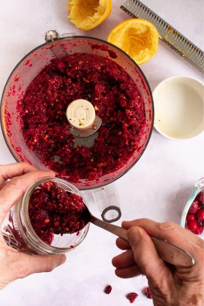 Cranberry relish in food processor scooped into small jar. | MakeSauerkraut.com