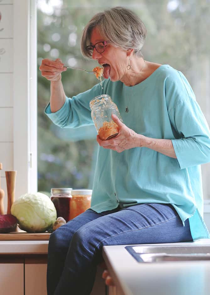 Holly Howe sitting on counter eating sauerkraut from the jar. | MakeSauerkraut.com