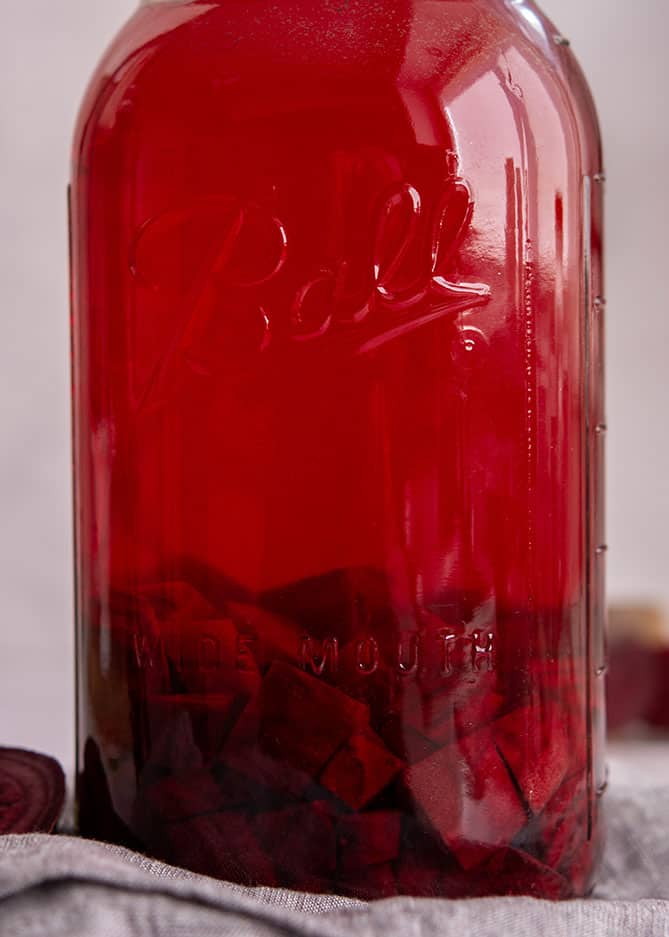 Tall jar of chopped beets in read salty brine. | MakeSauerkraut.com