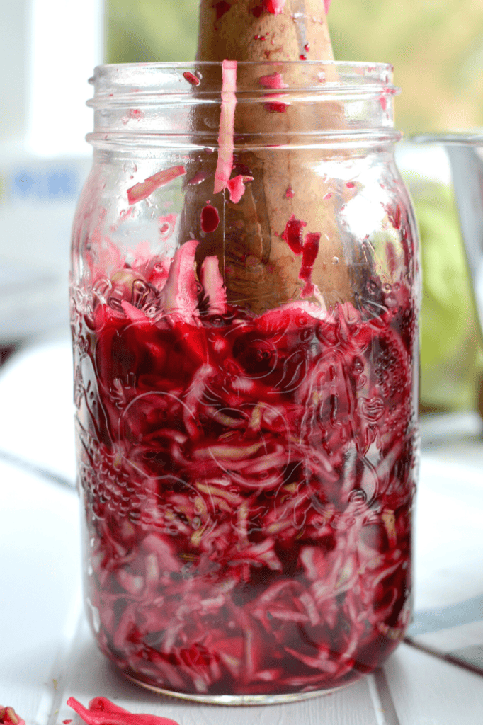 A batch of Red Beet and Cabbage Sauerkraut being packed in a jar. 