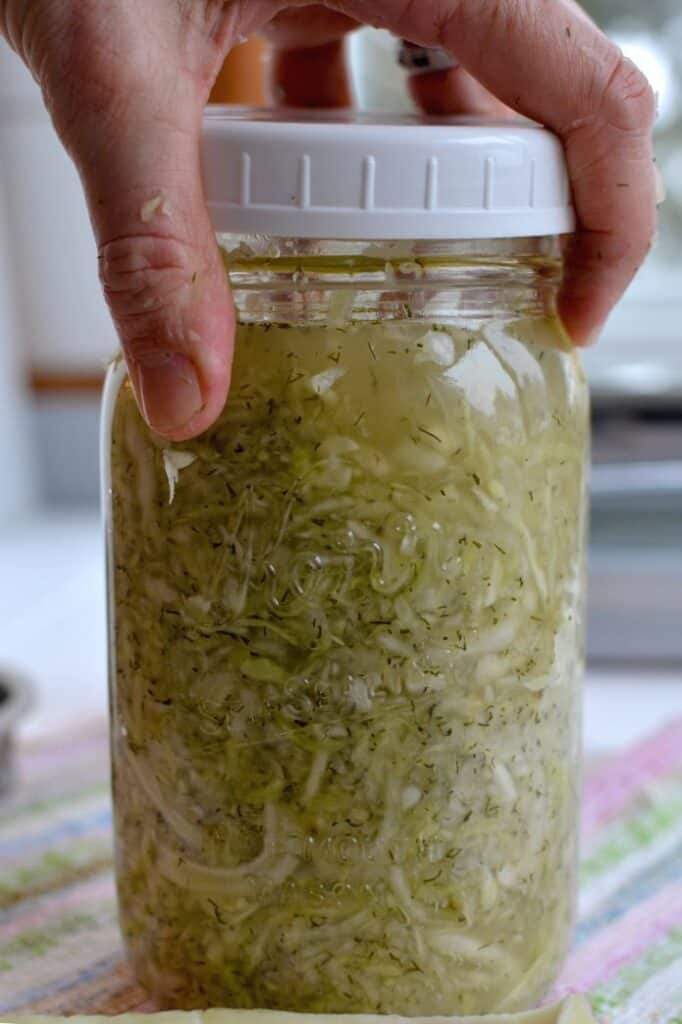 Screwing lid on to jar of dill sauerkraut. | MakeSauerkraut.com