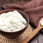 Sour cream in a wooden bowl on a mat.| MakeSauerkraut.com