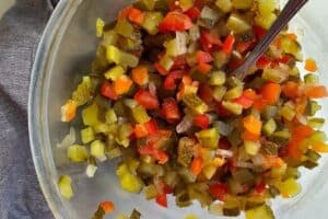A bowl of chopped vegetables with a spoon in it. | MakeSauerkraut.com